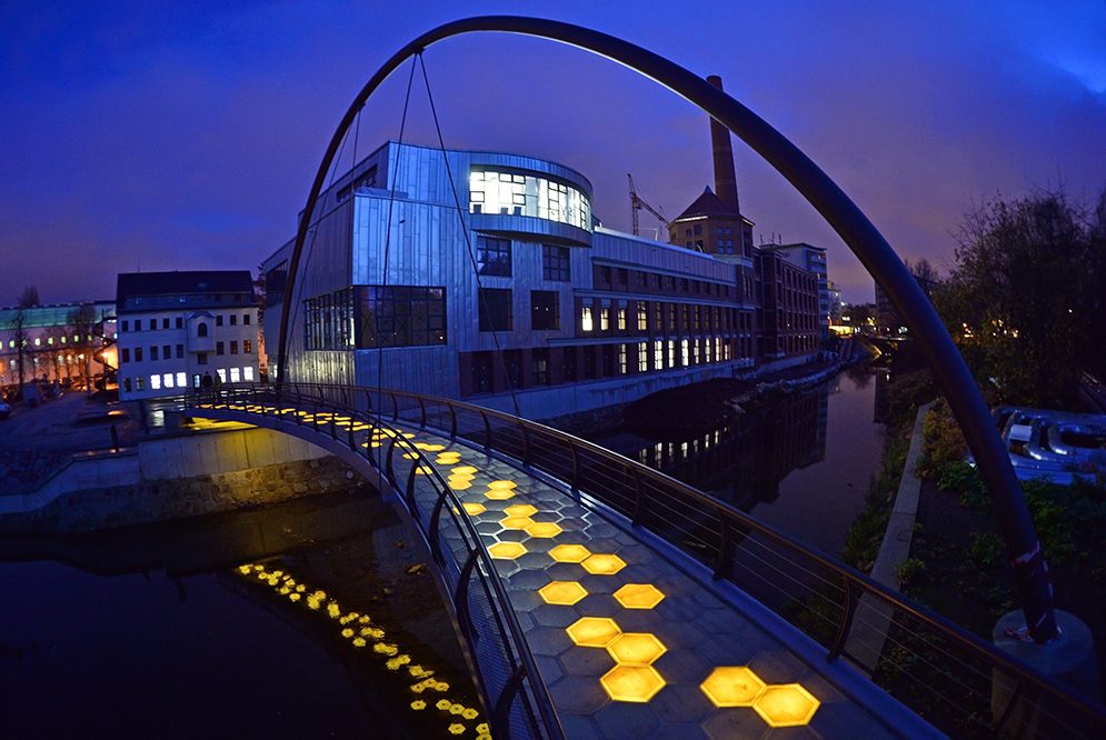 Gehbelag aus Glasfaser-Kunststoff-Verbund, realisiert mit ca. 2,60 m langen Modulen als Wabensandwich auf einer Brücke mit ca. 30 m Spannweite in Chemnitz. Die Integration einer interaktiven LED-Beleuchtung gestattet verschiedene Lichtszenarien. (© Andreas Ehrlich; TU Chemnitz, LBW)